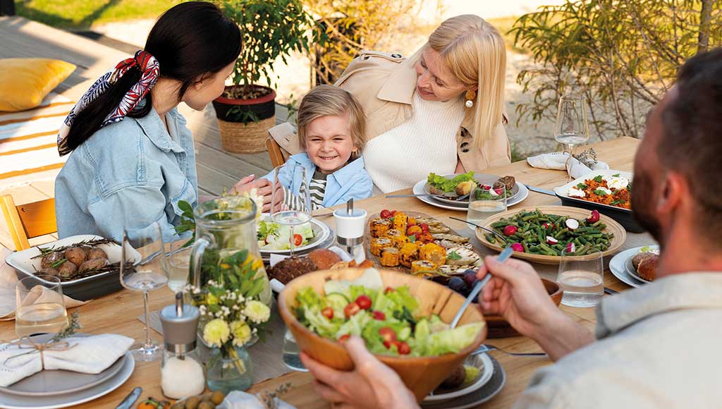 Une famille profitant d'un déjeuner en plein air sur la terrasse de leur maison