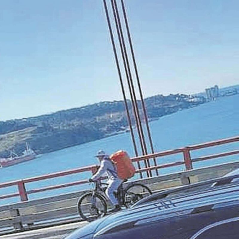 Un coursier à vélo « prend la vie en main » pour livrer de la nourriture sur le pont de Lisbonne