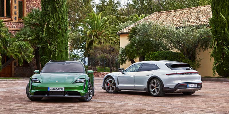 Photo de deux Porsche Taycan devant une maison de campagne